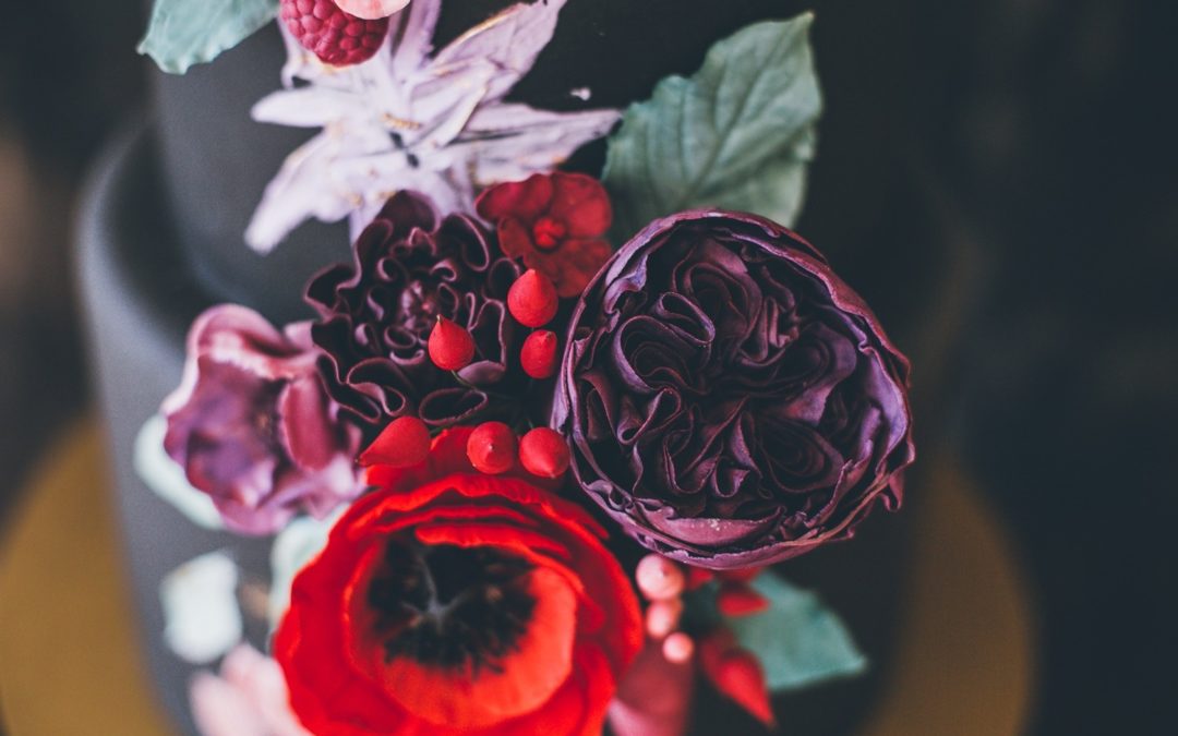 Extravagante Hochzeitstorte in schwarz mit üppiger Blumendekoration